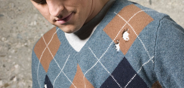 Man wearing sweater with holes, outdoors